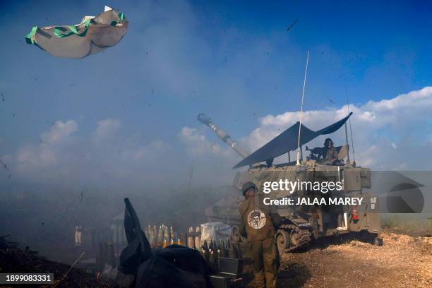 An Israeli soldier wearing a patch on the back of his flack jacket showing Lebanon's Hezbollah leader Hassan Nasrallah as a target, stands in front...