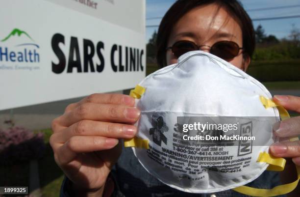 Reporter Wendy Luo holds up a N95 mask manufactured by 3M, one of the only masks that guards against germs such as severe acute respiratory syndrome...