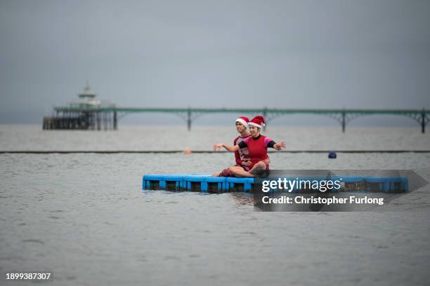 People wearing Santa hats herald the new year with a bracing swim in Clevedon Marine Lake on January 01, 2024 in Clevedon, United Kingdom. Bathers...