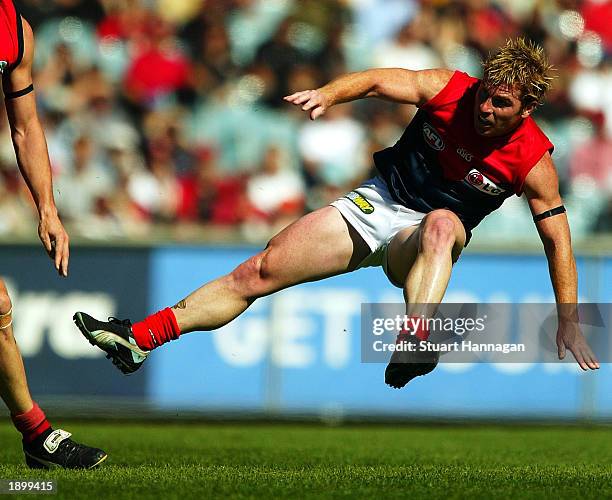 Gary Moorcroft of Melbourne gets a mid air kick away during the AFL Round two match between the Essendon Bombers and the Melbourne Demons at the...