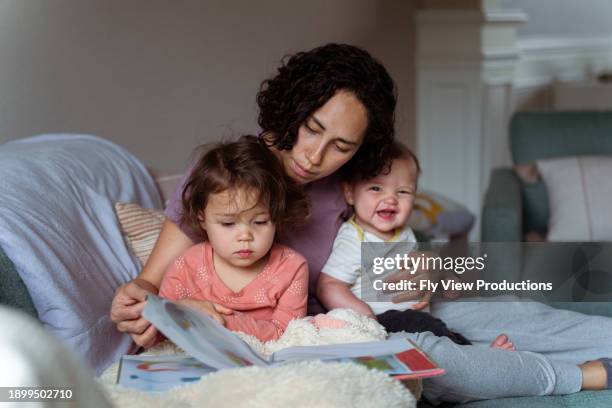 mom enjoying relaxing morning at home with sleepy and happy kids - toddler reading stock pictures, royalty-free photos & images