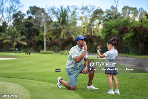 young girl high fives her father after golf lesson - kids clubhouse stock pictures, royalty-free photos & images