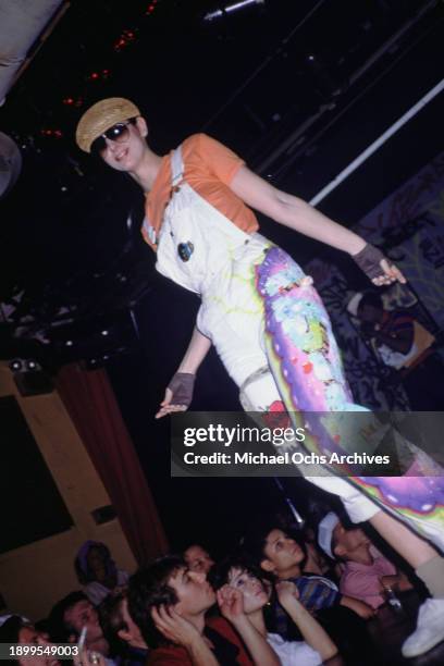 Fashion model wearing white dungarees embellished with graffiti over an orange t-shirt, on the runway at the Graffiti Fashion Show, held at the...