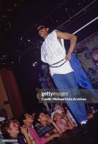 Fashion model, wearing a sleeveless white t-shirt embellished with handwriting and jeans on the runway at the Graffiti Fashion Show, held at the...