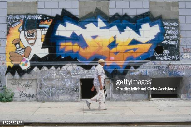 Man walking past a graffitied wall outside the Graffiti Fashion Show, held at the Danceteria on West 21st Street in Manhattan, New York City, New...