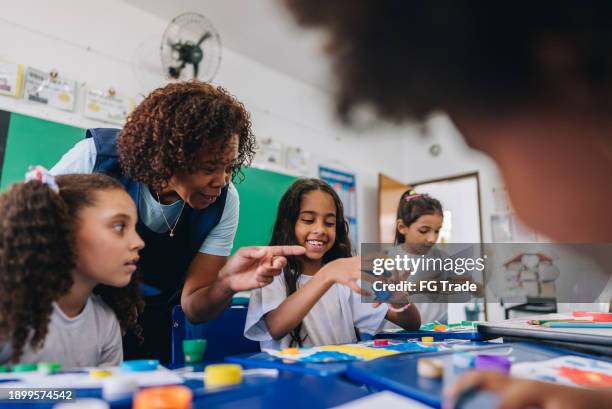 teacher teaching her students on art class at school - teacher stockfoto's en -beelden