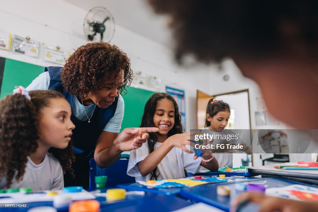 Teacher teaching her students on art class at school
