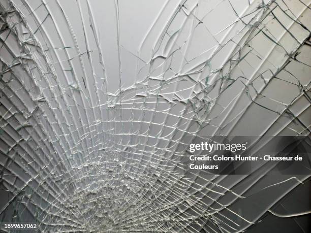 close-up of a window shattered by an impact in paris, france - scherben boden stock-fotos und bilder