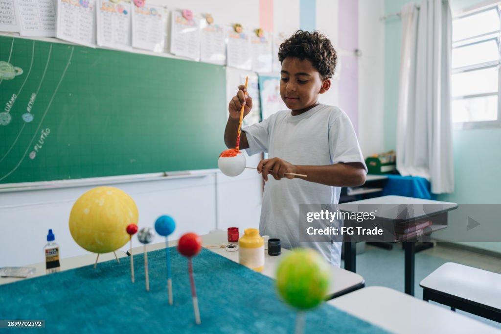 Boy Student Making A System Solar Model Project On Classroom At School ...