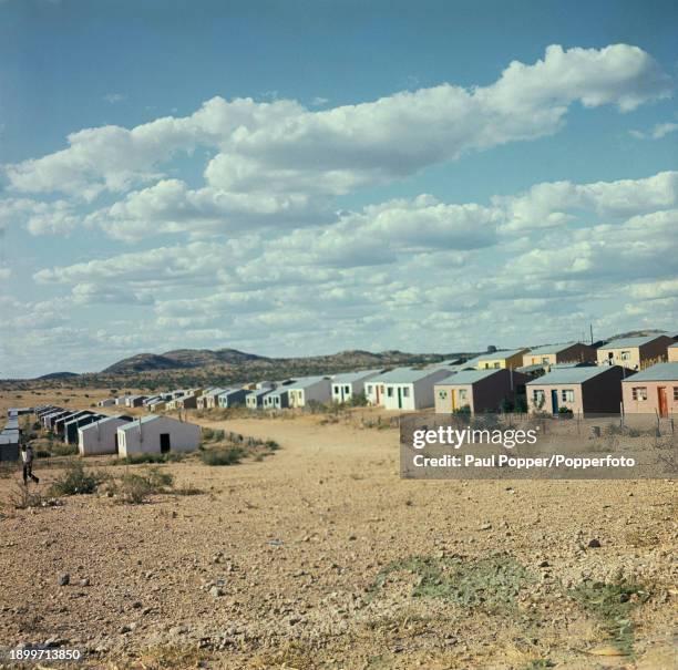 Man walks past houses in the recently built township of Katutura located to the north of the city of Windhoek in South West Africa circa 1961.