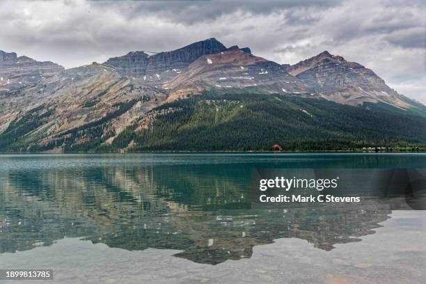 reflections with mount jimmy simpson and the lodge at bow lake - bow river stock pictures, royalty-free photos & images