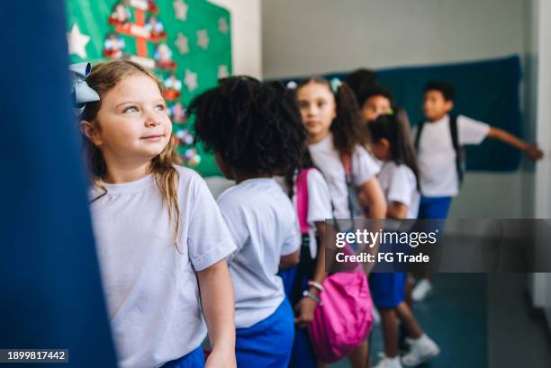 estudiante esperando en la fila y contemplando en la escuela - mirar alrededor fotografías e imágenes de stock