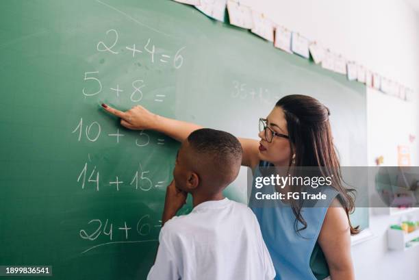teacher teaching the student on classroom at school - wiskunde stockfoto's en -beelden