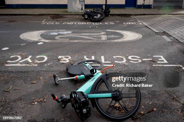 Motorbike and rental bike remain on the ground after being blown over during the high winds of Storm Henk passed through south London, in Herne Hill,...