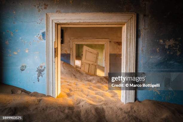 abandoned house in the desert full of sand, namibia - kolmanskop stockfoto's en -beelden