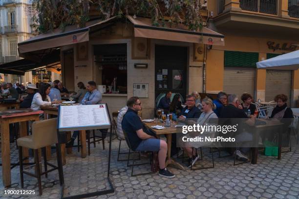 People are enjoying the atmosphere on the terrace of the 21 Bou tavern, known for offering a taste of the local gastronomy and its famous wines in...