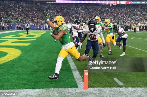 Kenyon Sadiq of the Oregon Ducks scores a second quarter touchdown against the Liberty Flames during the 2023 Vrbo Fiesta Bowl game at State Farm...