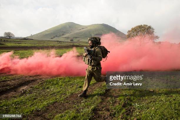 An Israeli reserve combat soldier of the Alexandroni brigade runs during a training exercise simulating operational scenarios on the Lebanese front...