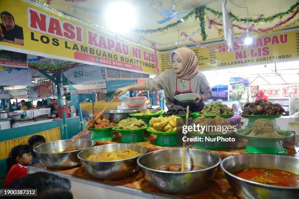 Waitress is serving a variety of dishes of Nasi Kapau at a culinary destination in Los Lambuang, Bukittinggi, West Sumatra, Indonesia, on January 1,...