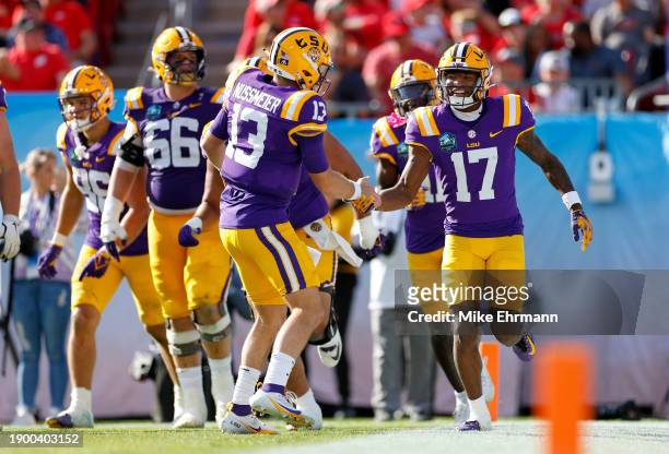 Garrett Nussmeier and Chris Hilton Jr. #17 of the LSU Tigers celebrates a touchdown during the ReliaQuest Bowl against the Wisconsin Badgers at...