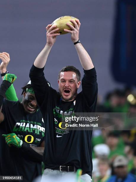 Head coach Dan Lanning of the Oregon Ducks hold up the 2023 Vrbo Fiesta Bowl championship trophy after beating the Liberty Flames 45-6 at State Farm...