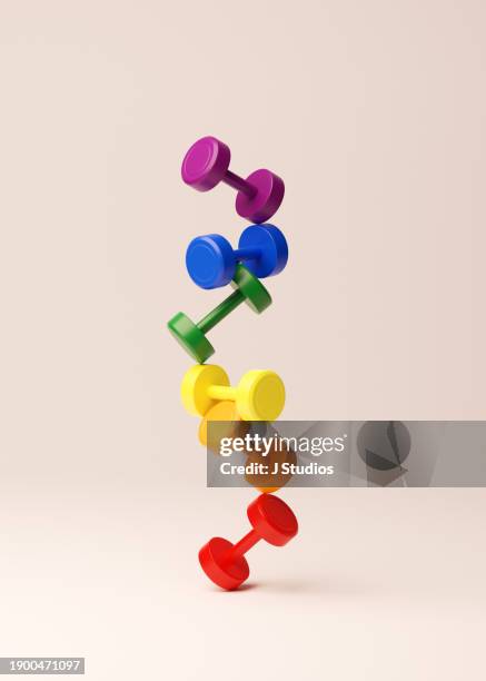 multi colored dumbbells stacked on top of eachother - gewicht fitnessausrüstung stock-fotos und bilder
