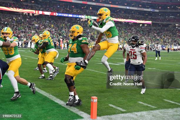 Tez Johnson of the Oregon Ducks scores a touchdown against the Liberty Flames during the third quarter of the 2023 Vrbo Fiesta Bowl at State Farm...