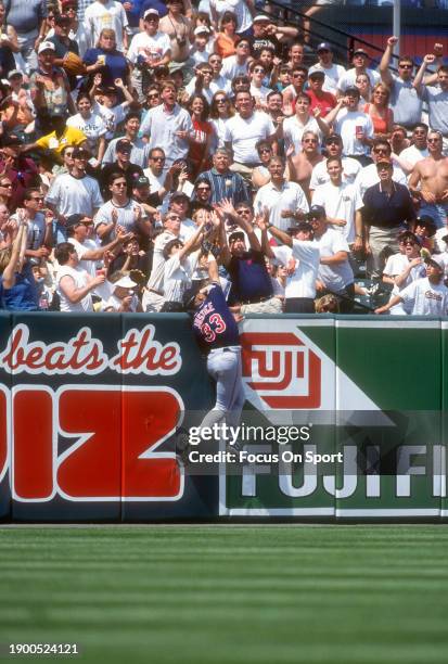 David Justice of the Cleveland Indians leaps for a ball at the wall that goes into the stands for a home run against the Baltimore Orioles during...