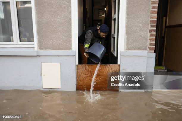 Man drains the water from a house with a bucket in the town of Saint-Omer, Pas-de-Calais, France on January 04, 2024.