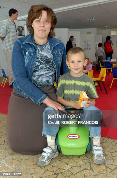 Paul se détend au côté de sa mère Isabelle après avoir été vacciné, le 12 juin 2006 à Dieppe, dans le cadre d'une campagne de vaccination sans...