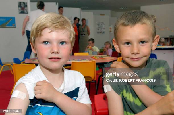 Luis et Paul montrent leur bras après avoir été vaccinés, le 12 juin 2006 à Dieppe, dans le cadre d'une campagne de vaccination sans précédent pour...