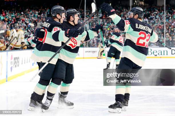 Yanni Gourde of the Seattle Kraken celebrates with Eeli Tolvanen and Oliver Bjorkstrand after scoring a goal during the third period of the 2024...