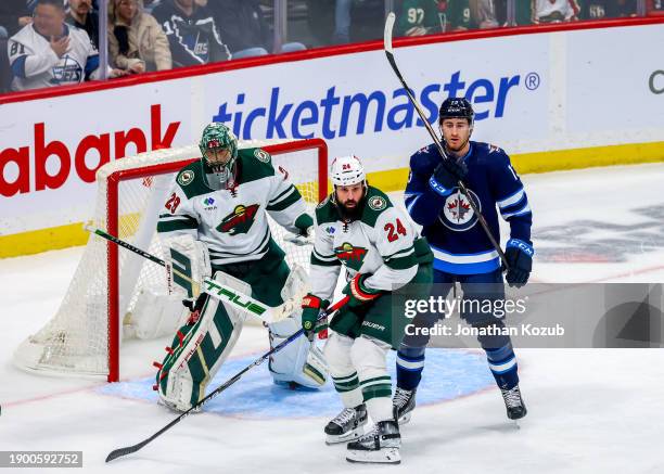 Gabriel Vilardi of the Winnipeg Jets keeps an eye on the play in front of goaltender Marc-Andre Fleury and Zach Bogosian of the Minnesota Wild during...