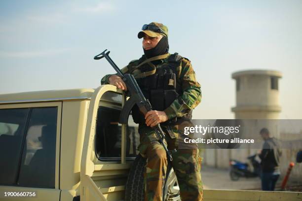 January 2024, Iraq, Baghdad: A member of the Popular Mobilization Forces , a powerful pro-Iranian militia, stands guard at the site where two members...