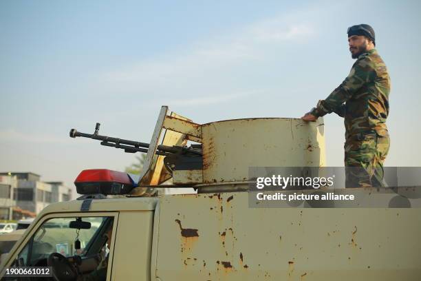 January 2024, Iraq, Baghdad: A member of the Popular Mobilization Forces , a powerful pro-Iranian militia, stands guard at the site where two members...