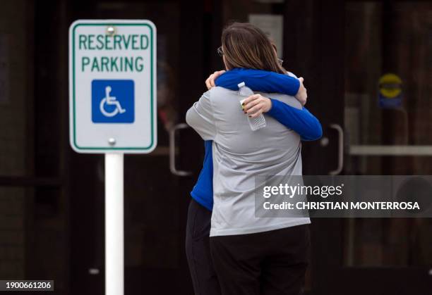 Two people embrace at a reunification center in the McCreary Community Building after a shooting at the Perry Middle and High School complex in...