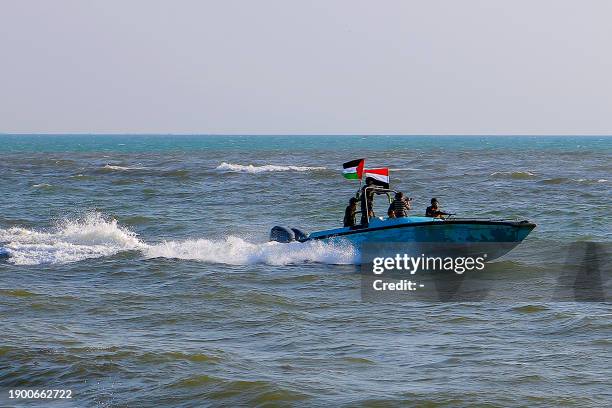 Members of the Yemeni Coast Guard affiliated with the Houthi group patrol the sea as demonstrators march through the Red Sea port city of Hodeida in...