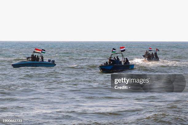 Members of the Yemeni Coast Guard affiliated with the Houthi group patrol the sea as demonstrators march through the Red Sea port city of Hodeida in...