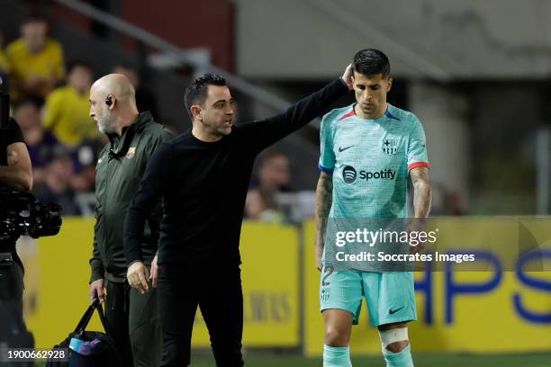 Coach Xavi Hernandez of FC Barcelona consoles Joao Cancelo of FC Barcelona who leaves the pitch with an injury during the LaLiga EA Sports match...