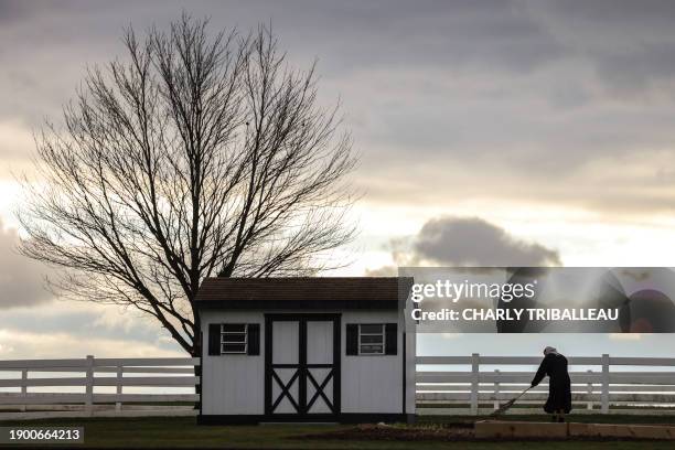 An Amish woman rakes her lawn in the town of Gap in Pennsylvania on January 4, 2023.