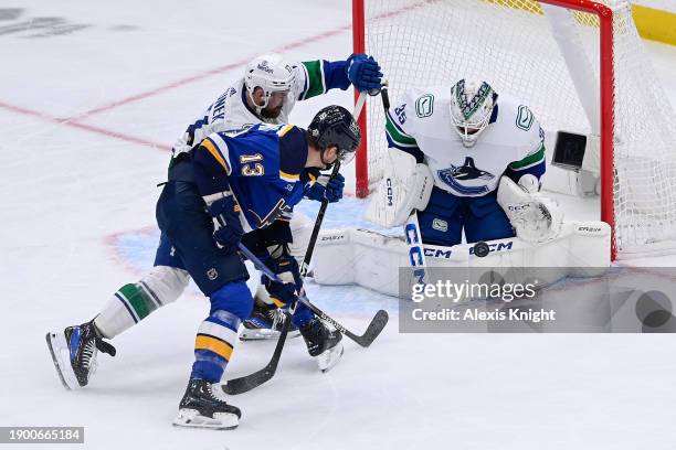 Thatcher Demko and Filip Hronek of the Vancouver Canucks defend the net against Alexey Toropchenko of the St. Louis Blues on January 4, 2024 at the...