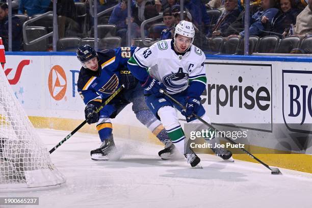 Jordan Kyrou of the St. Louis Blues pressures Quinn Hughes of the Vancouver Canucks on January 4, 2024 at the Enterprise Center in St. Louis,...