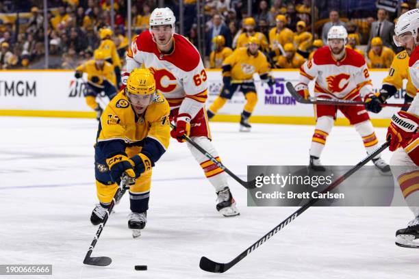 Luke Evangelista of the Nashville Predators reaches for the puck against the Calgary Flames during the first period at Bridgestone Arena on January...