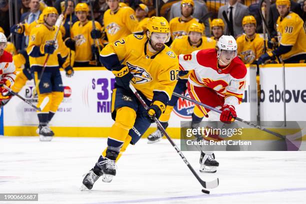 Tommy Novak of the Nashville Predators skates the puck against the Calgary Flames during the first period at Bridgestone Arena on January 4, 2024 in...