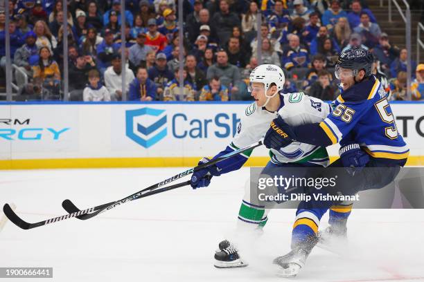 Teddy Blueger of the Vancouver Canucks races Colton Parayko of the St. Louis Blues to the puck in the second period at Enterprise Center on January...