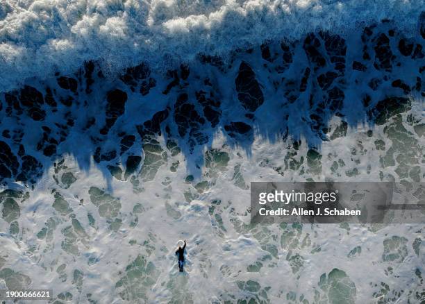 Huntington Beach, CA A surfer struggles to paddle against strong currents and through large breaking waves in Huntington Beach created by an...