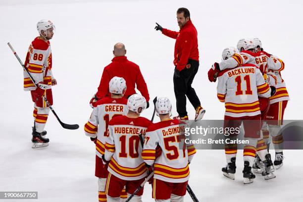 Dennis Gilbert of the Calgary Flames is helped off the ice by teammates after an injury during the third period against the Nashville Predators at...