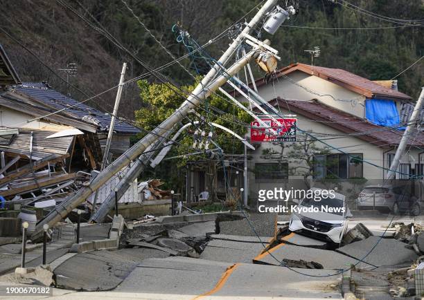 Car sits on a damaged road in Wajima, Ishikawa Prefecture, on Jan. 5 following a strong earthquake that jolted the Noto Peninsula and surrounding...