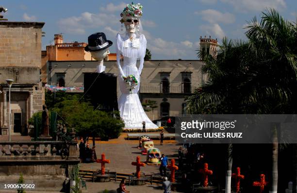 View of a 20-meter-high "Catrina" figure -the biggest in the world-, dressed up as a bride, and the "Catrin", her groom, in the main square of...