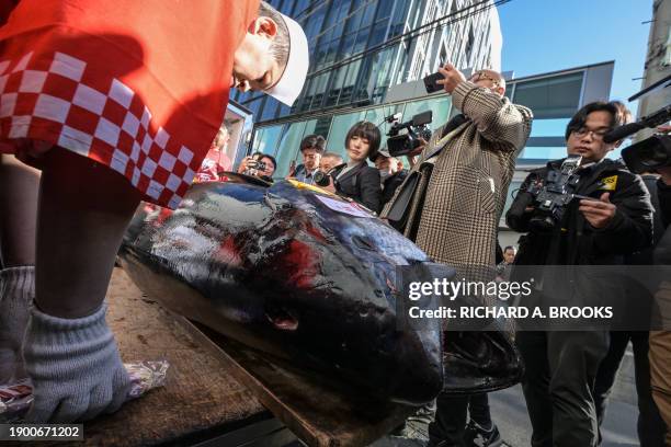 Members of the media crowd around as a 238-kilo bluefin tuna - which was purchased earlier in the day for 788,440 USD at the first tuna auction of...